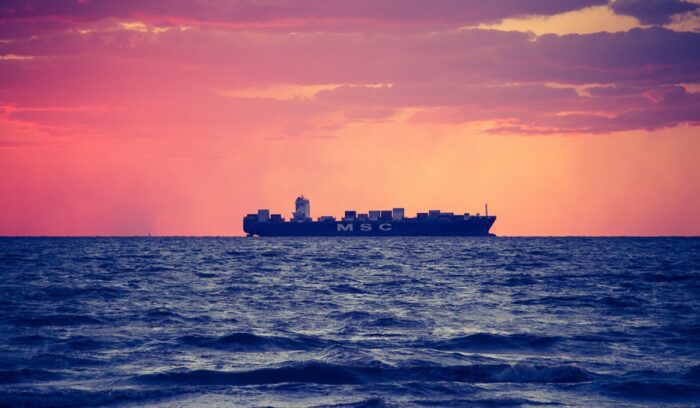 A large cargo ship sailing on calm ocean waters for an article about shipping decarbonization