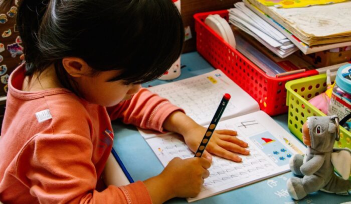 Child with pen and paper, for article on kindergarten readiness gap