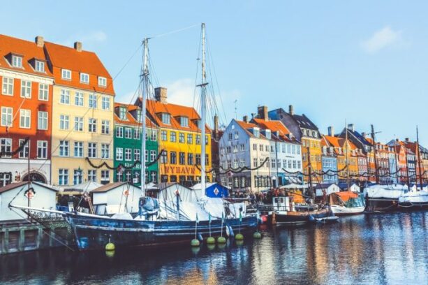 Cyclists riding through Copenhagen's cycling infrastructure network with dedicated bike lanes along a city street