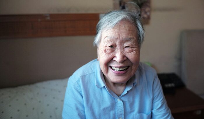 Elderly person smiling, for article on global life expectancy gains