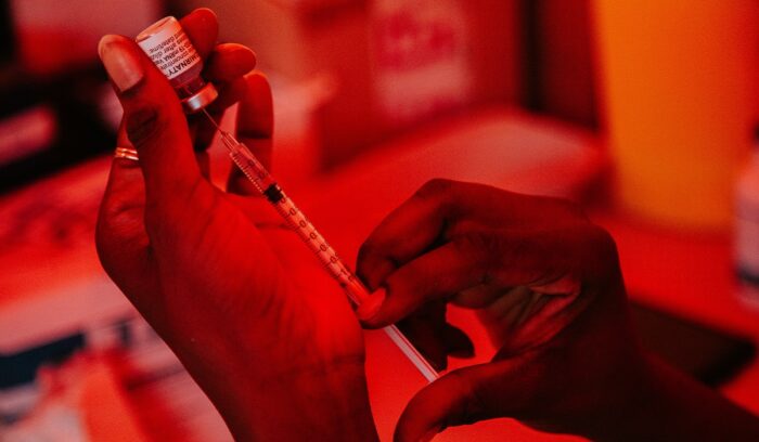 Hand extracting vaccine from vial