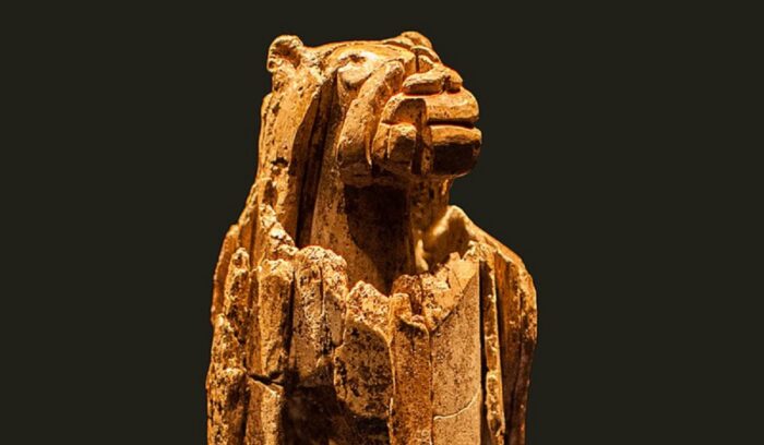 A carved ivory figurine with a human body and lion head for an article about lion-man figurine