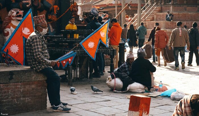 Man holding Nepali flag in a crowd