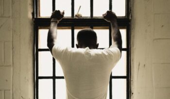 Empty prison corridor with open cell doors for an article about global prison population
