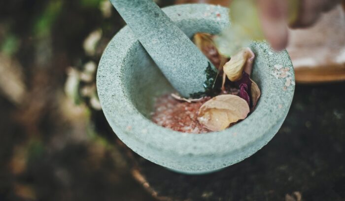 Ancient stone mortar and pestle on a rough surface for an article about mortar and pestle invention
