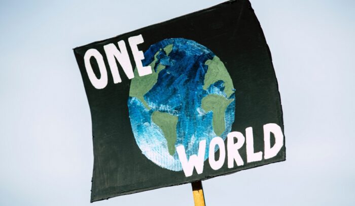 "One World" sign, for article on Swiss women's climate case
