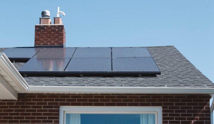 Rooftop solar panels on suburban houses in bright sunlight, for an article about England's solar panel mandate for new homes, for article on solar panel mandate, for article on Australia rooftop solar record