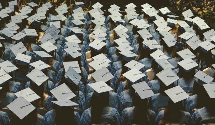 Rows of students at graduation, for article on student loan forgiveness