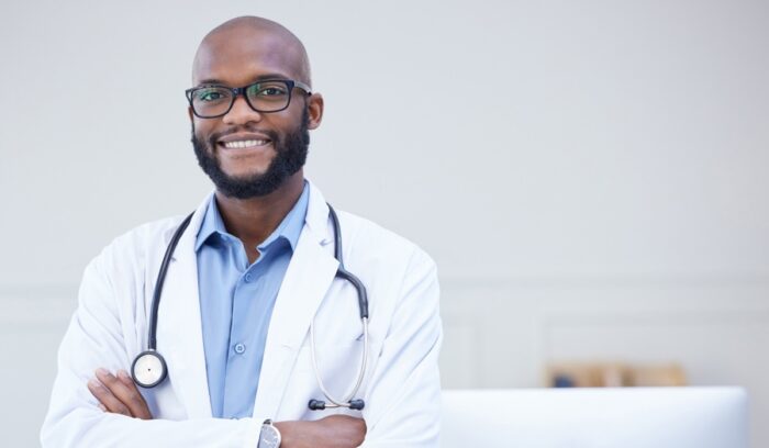Shot of a young male doctor standing with his arms crossed in an office at a hospital, for article on HBCU medical school funding