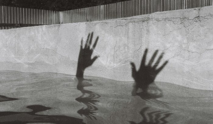 Silhouette of hands just above the waterline|ryan whitlow unsplash