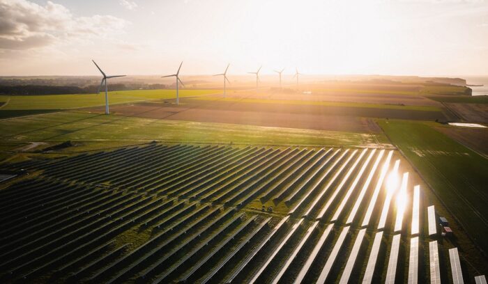 Solar farm with wind turbines representing breakthrough energy ventures in renewable power generation