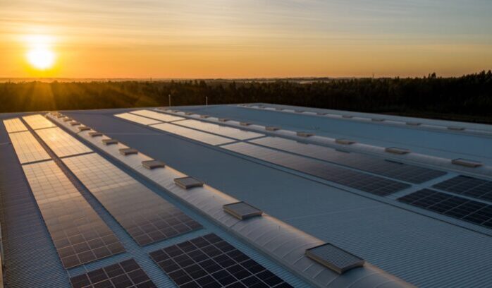 Solar panels on a building with sun in background, for article on Australia solar power