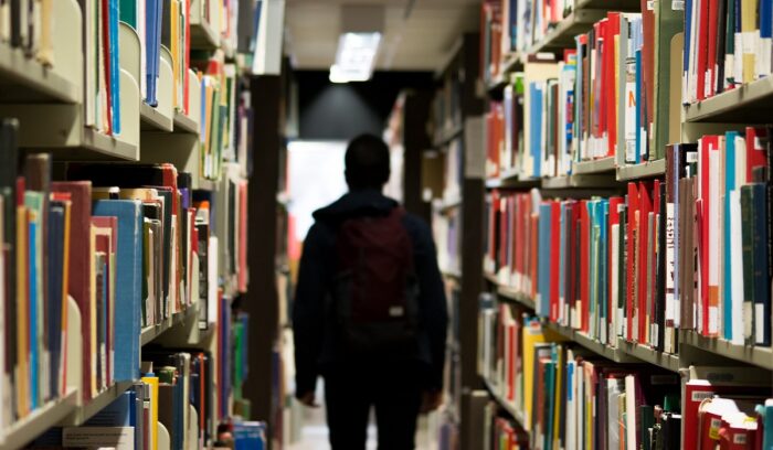 Student in a library with back turned