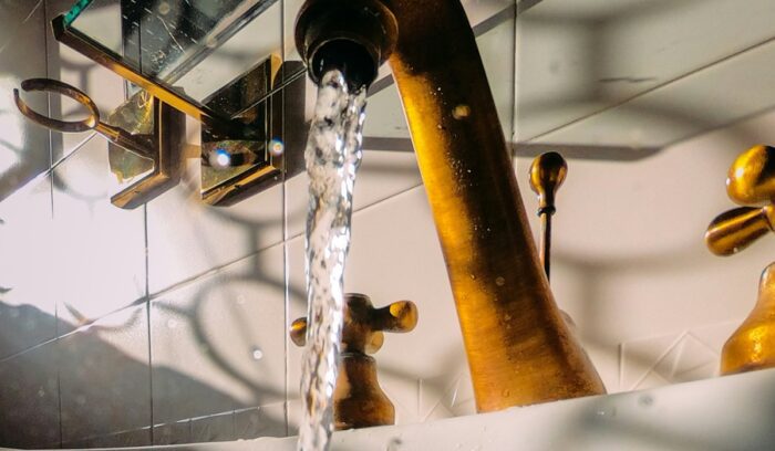 Water flowing from faucet, for article on PFAS drinking water limits