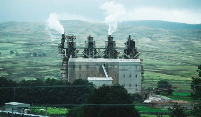 White building causing air pollution in the countryside|joe tree unsplash