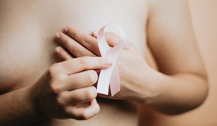 A medical researcher reviewing cancer treatment data in a laboratory, for an article about breast cancer immunotherapy