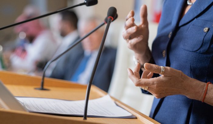 Female politician at podium, for article on female legislative majority