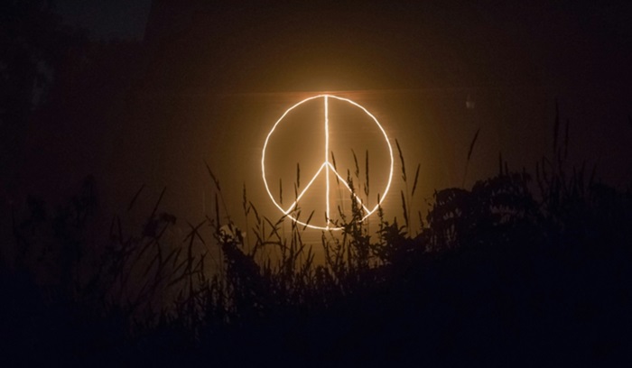 Peace sign lit in the sky at night