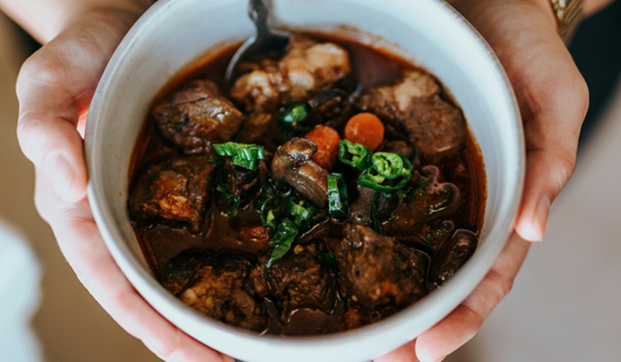 Hands holding a bowl of stew, representing the stew of change, from article: What is change