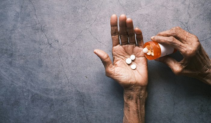 A doctor reviewing a prescription pad in a clinical setting for an article about non-opioid pain drug approval