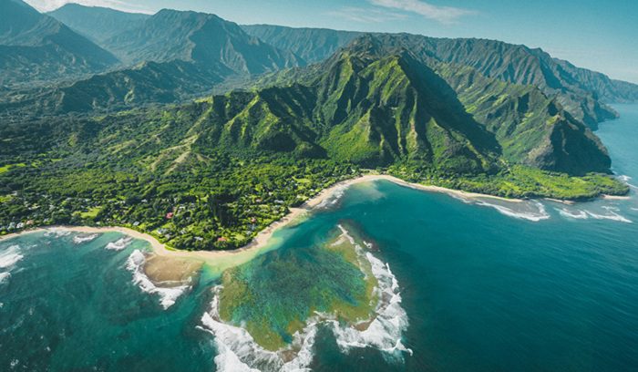 Aerial view of a Hawaiian coral reef and turquoise coastline for an article about Hawaii climate resilience fee