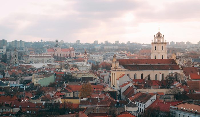 Rainbow flag flying above a European city square for an article about same-sex family recognition in Lithuania