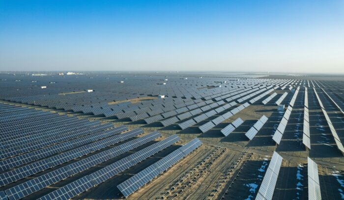Rows of solar panels stretching across a large installation at sunset for an article about solar power installations