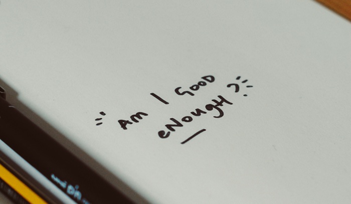 "Am I good enough?" written on a notebook