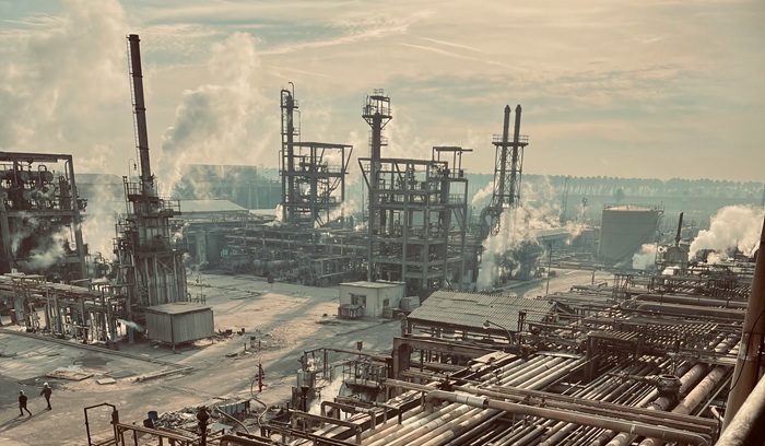 An oil and gas facility at dusk with visible flaring for an article about Canada methane regulations