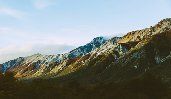Granite peaks rising above a forested river valley for an article about Patagonia conservation in Chile's Cochamó district