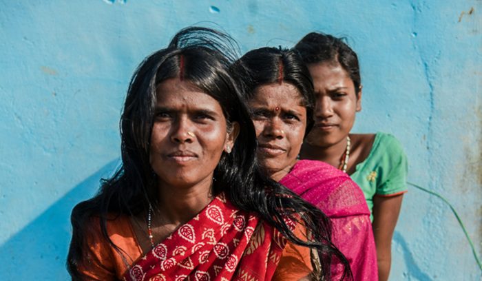 Indian women at a community gathering for an article about women cash transfers and unpaid domestic labor recognition