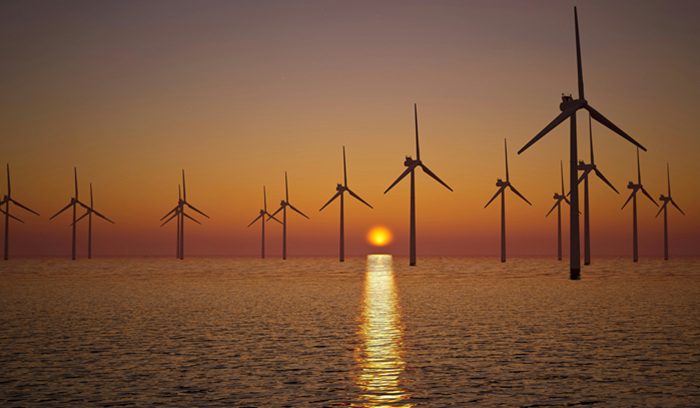 Offshore wind turbines at sea at dusk for an article about U.K. offshore wind auction results