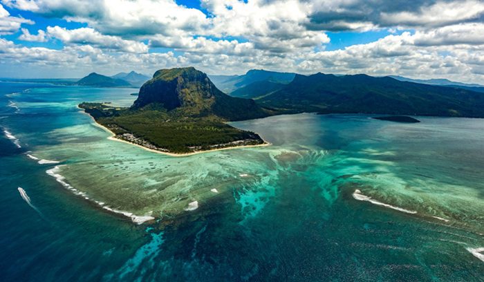 Colorful coral reef with tropical fish in clear blue water for an article about Mauritius coral restoration