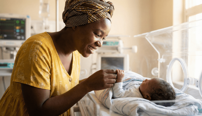 A premature newborn in an incubator with medical monitoring equipment, for an article about Sierra Leone neonatal intensive care unit