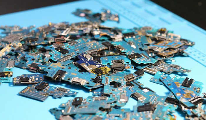Discarded electronics and circuit boards piled at a waste site, for an article about Malaysia's e-waste ban