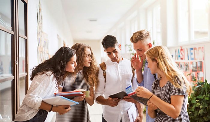 A student placing a smartphone in a storage pouch for an article about the student phone ban in New Jersey schools