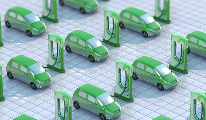 A row of electric vehicles charging at public stations for an article about electric car sales in the E.U.