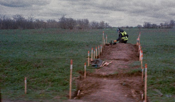 A deminer in protective gear scanning a field for an article about Croatia landmine free clearance efforts