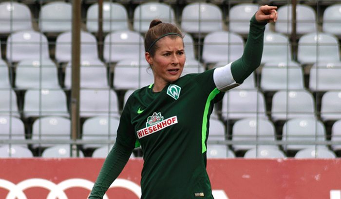 A woman coach gesturing instructions on a football sideline for an article about female head coach in men's top-five European leagues