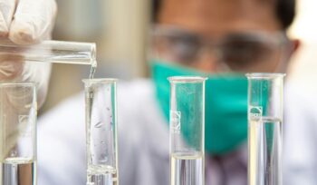 Scientist filling tubes, for article on reversible male contraception