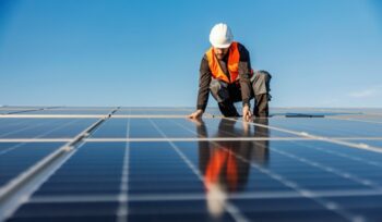 Man installing solar panels, for article on solar PV growth