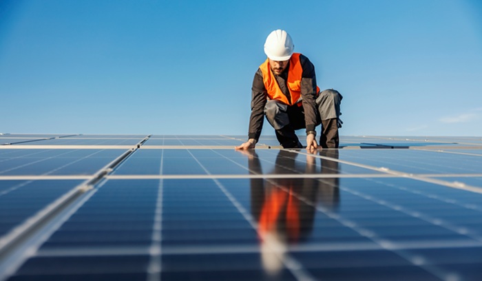 Man installing solar panels, for article on solar PV growth