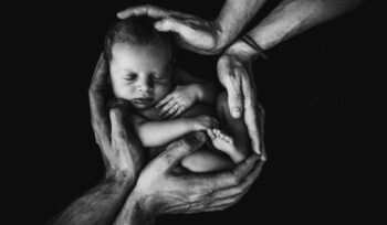 Two sets of hand holding newborn baby, for article on Coartem Baby malaria treatment