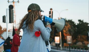 Female protester with megaphone, for article on rape kit reform