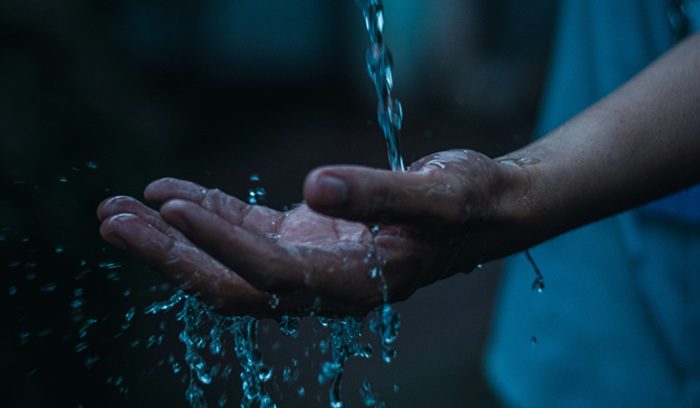Water falling on hand, for article on clean water access