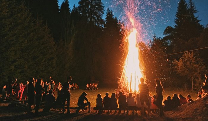 People gathered around a large bonfire at night